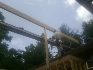 Carpenter setting a ridge beam over a new addition frame — Ice Dam Removal by Roofing Brothers in Kenoza Lake