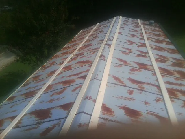 Rusted metal roof panels with new wood purlins before replacement — Storm Damage Roof Repair in Kenoza Lake by Roofing Brothers