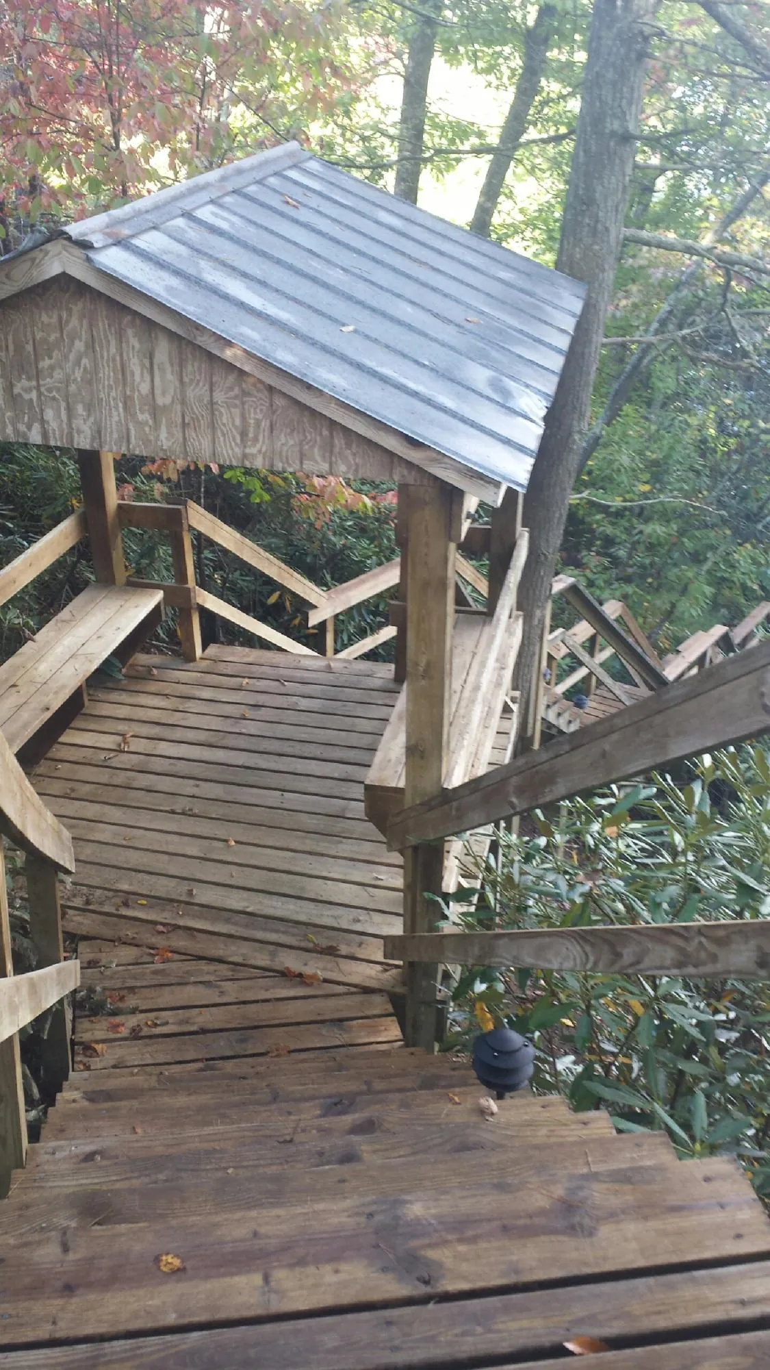 Metal roofed shelter over wooden steps on a wooded walkway — Skylight Repair & Installation work by our crew in Kenoza Lake
