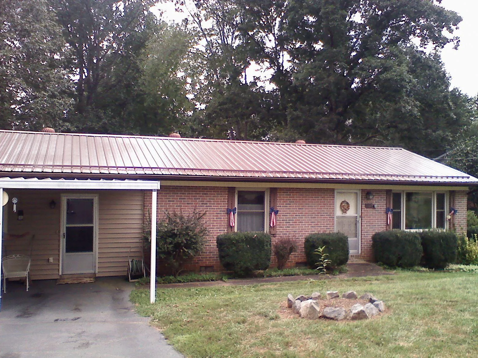 Bronze metal roof and carport on a brick ranch home — Roof Repair work by our crew in Kenoza Lake